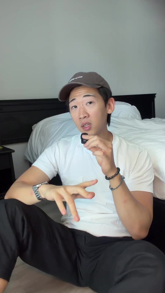 Julian sitting on a bed, recording with a small microphone